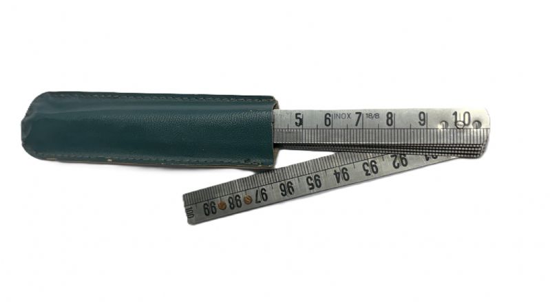 metro inox con 10 stecche e molle lunghezza 100 mm x larghezza 12 mm chiuso. Completo di custodia protettiva con i primi 5 cm muniti di scala a 1/2 mm